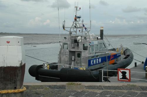 a boat is docked in the water next to the ocean at B&B Molenaar in Buren