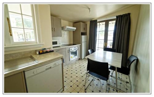 a kitchen with a table and chairs in a room at Lantern Court Motel in Reefton