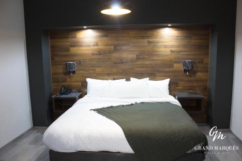 a bedroom with a large bed with a wooden wall at Grand Marques in San Juan de los Lagos