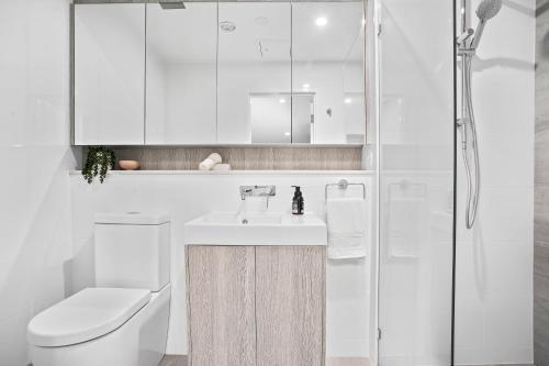 a bathroom with a sink and a toilet and a shower at No 5 Rockpool 69 Ave Sawtell in Sawtell