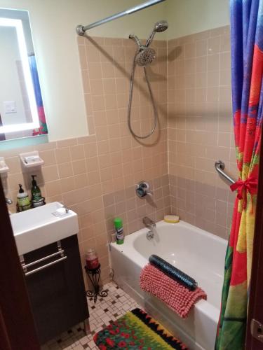 een badkamer met een douche, een bad en een wastafel bij Spacious Fully Furnished Harlem Apartment Near Morningside Park in New York