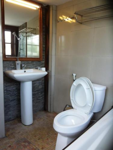 a bathroom with a white toilet and a sink at The Dream Home Villas in Denpasar