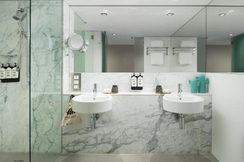 a bathroom with two sinks and a shower at Ovolo The Valley Brisbane in Brisbane
