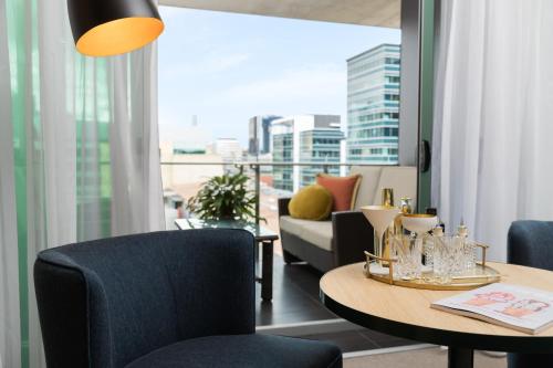 a living room with a table and chairs and a large window at Ovolo The Valley Brisbane in Brisbane