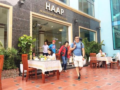 a group of people walking in front of a restaurant at HAAP Transit Hotel in Noi Bai