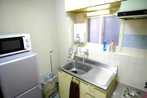 a small kitchen with a sink and a window at Seikan bildinng101 in Hakodate