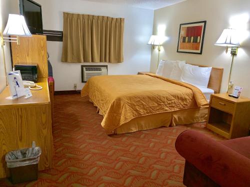 Habitación de hotel con cama y sofá en Americas Best Value Inn and Suites Sidney, en Sidney