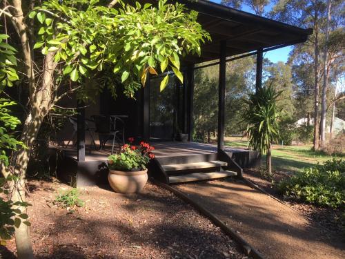 a pavilion with a bench and flowers in a garden at Hunter Valley Retreat in Quorrobolong