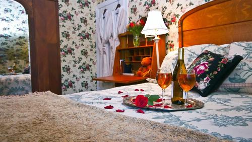 a bed with two glasses of wine and roses on it at Elk Forge Bed and Breakfast in Elkton