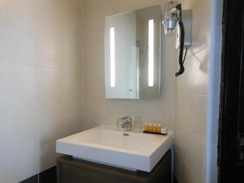 a bathroom with a white sink and a mirror at The Concert Hotel in Amsterdam