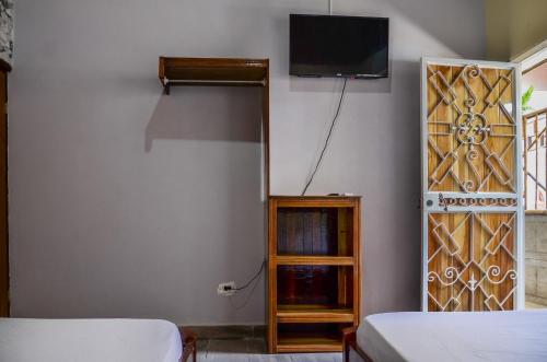 1 dormitorio con 1 cama y TV en la pared en Cabinas Coco Alegre en Coco