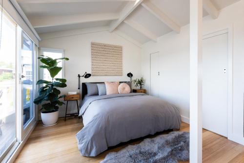 a bedroom with a bed and a large window at Litora Accommodation in Hobart