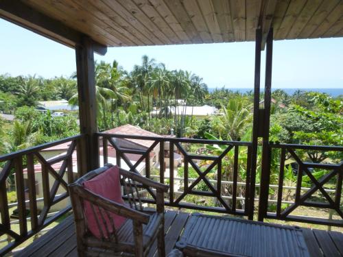 a porch with two chairs and a view of the ocean at Chez Solange et Michel in Sainte-Rose