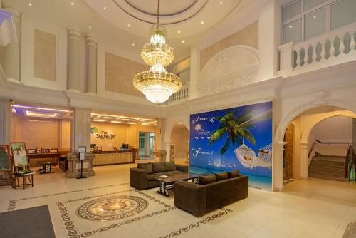 a large lobby with a chandelier and a living room at The Sailing Bay Beach Resort in Mui Ne