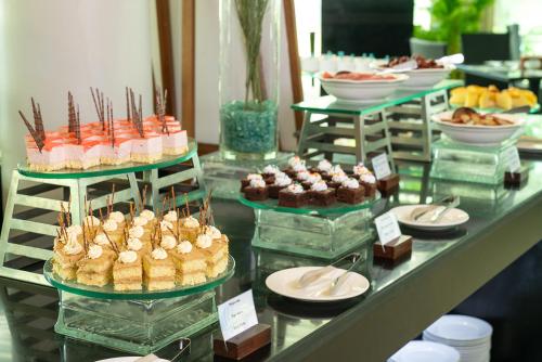 a buffet of pastries and desserts on a table at The Sailing Bay Beach Resort in Mui Ne