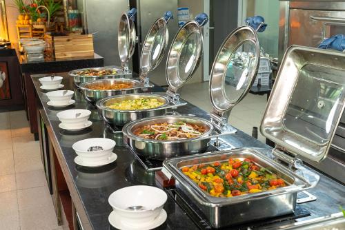 a buffet line with many trays of food at The Sailing Bay Beach Resort in Mui Ne