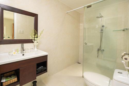 a bathroom with a shower and a sink and a toilet at The Sailing Bay Beach Resort in Mui Ne