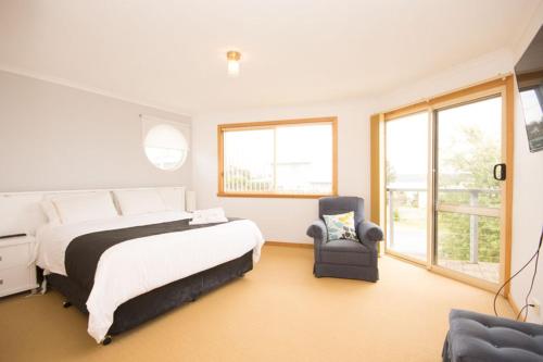a bedroom with a large bed and a chair at St Helens On The Bay in St Helens