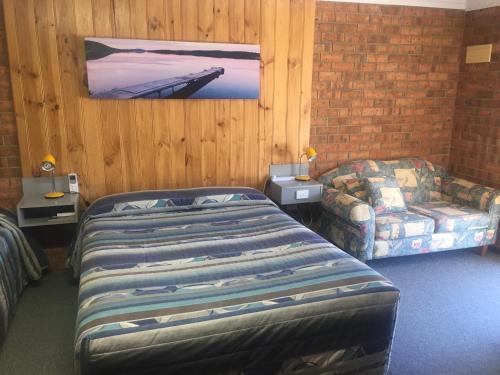 a bedroom with a bed and a couch and a picture at Kadina Gateway Motor Inn in Kadina
