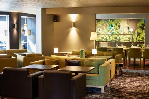 a lobby with couches and tables and a restaurant at Best Western Plus Clos Syrah in Valence