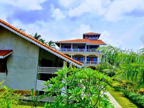 a house with a tower on top of it at Thambili Cabanas in Hikkaduwa