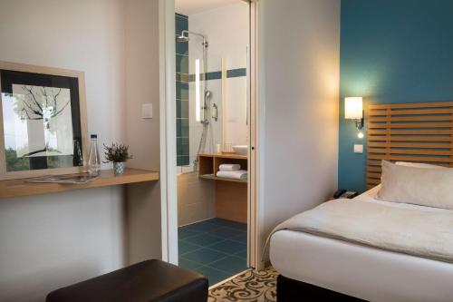 a hotel room with a bed and a shower at Best Western Plus Hotel De La Regate-Erdre in Nantes