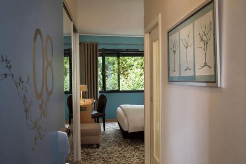 a room with a bedroom with a bed and a mirror at Best Western Plus Hotel De La Regate-Erdre in Nantes