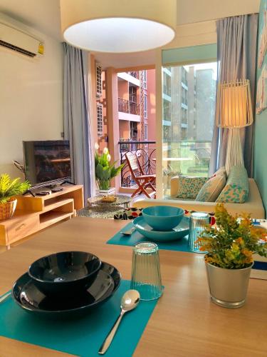 a table with plates and spoons on top of it at Atlantis Condo Resort Pattaya - Heaven for Family & Kids with Big Water Park in Jomtien Beach