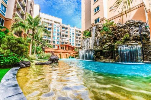 ein Schwimmbad mit Wasserfall in einem Gebäude in der Unterkunft Atlantis Condo Resort Pattaya - Heaven for Family & Kids with Big Water Park in Jomtien Beach
