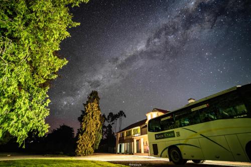a bus parked in front of a building under a night sky at Teschemakers Resort in Oamaru