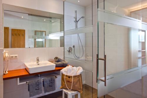 a bathroom with a sink and a shower at Hotel Lukas in Fiss