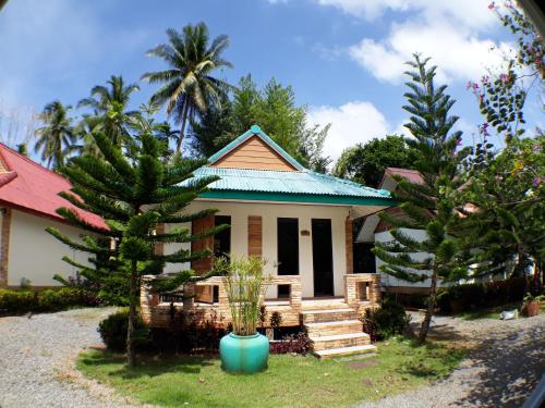 a house with a palm tree in front of it at Riverside Palm Resort - Surat Thani in Ban Bang Pho