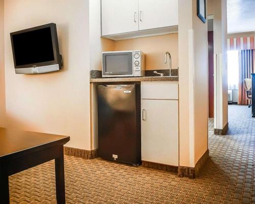 a kitchen with a microwave and a television on the wall at Quality Inn & Suites Roswell North in Roswell