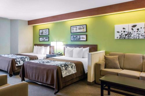 a hotel room with two beds and a couch at Sleep Inn & Suites Oregon - Toledo in Oregon
