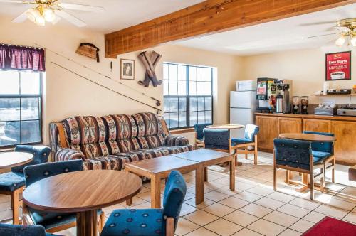 uma sala de estar com um sofá, mesas e cadeiras em Econo Lodge em Eagle Nest