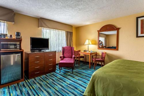 a hotel room with a bed and a flat screen tv at Quality Inn in Los Lunas