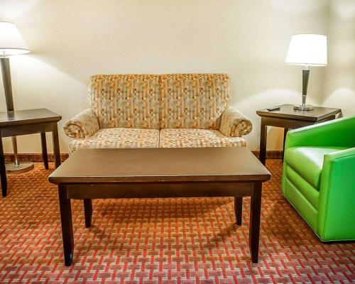 a living room with a couch and a green chair at Quality Inn & Suites Roswell North in Roswell