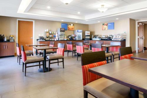 a restaurant with tables and chairs and a bar at Comfort Inn & Suites Norman near University in Norman