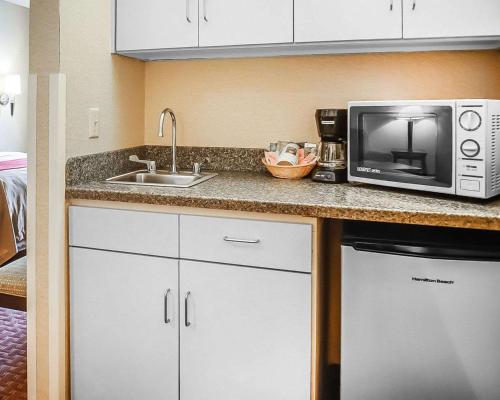 a kitchen with a sink and a microwave at Quality Inn & Suites Roswell North in Roswell