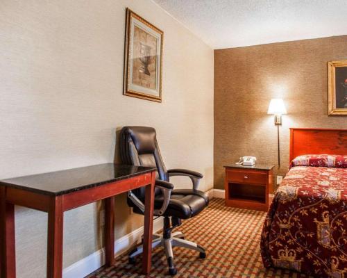 a hotel room with a desk and a bed at Rodeway Inn in Paterson