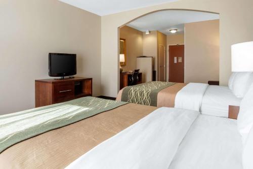 a hotel room with two beds and a flat screen tv at Comfort Inn & Suites Norman near University in Norman