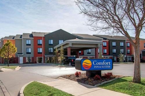 a sign in front of a building with a comfort inn at Comfort Inn & Suites Norman near University in Norman