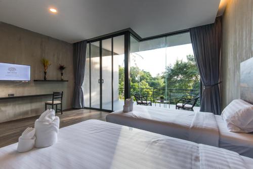 a hotel room with two beds and a balcony at Matina Mountain Resort in Ko Tao