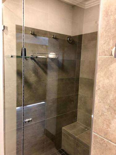 a shower with a glass door in a bathroom at Belaire Suites Hotel in Durban