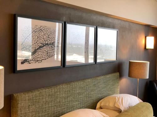 a bedroom with three windows and a bed at Belaire Suites Hotel in Durban
