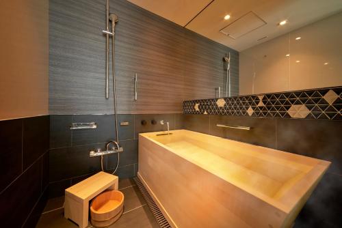 a bathroom with a wooden tub and a toilet at Hotel New Otani Tokyo The Main in Tokyo