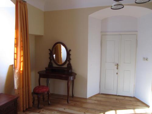 a room with a mirror and a table with a stool at Penzion na Faře in Dubenec