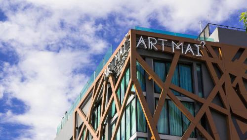 a building with a sign on the top of it at Art Mai Gallery Nimman Hotel Chiang Mai in Chiang Mai