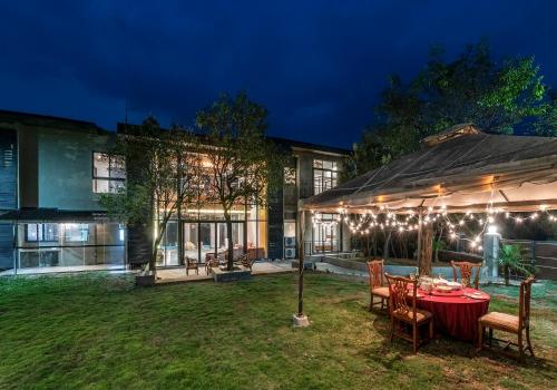 a patio with a table and chairs in front of a house at SaffronStays Falcon Hill, Lonavala - luxury villa with infinity pool near Lion's Point in Lonavala