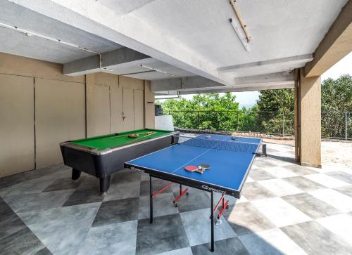 a ping pong table in the middle of a patio at SaffronStays Falcon Hill, Lonavala - luxury villa with infinity pool near Lion's Point in Lonavala